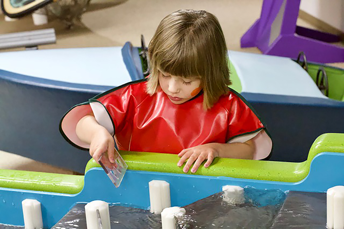 child playing with the water table